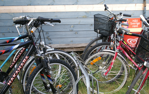 Flera cyklar som står i ett cykelställ.