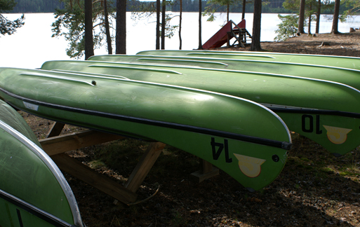 Gröna kanoter ligger upp och ner vid Oresjön.