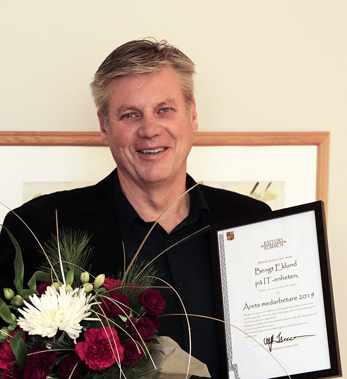 Porträtt på Bengt Eklund med blommor och plakett.