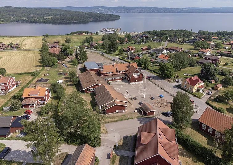 Flygfoto över Vikarbyn och Vikarbyns skola. Sjön Siljan syns i bakgrunden.